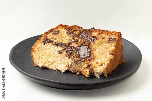 Sliced panettone stuffed with chocolate on plate.