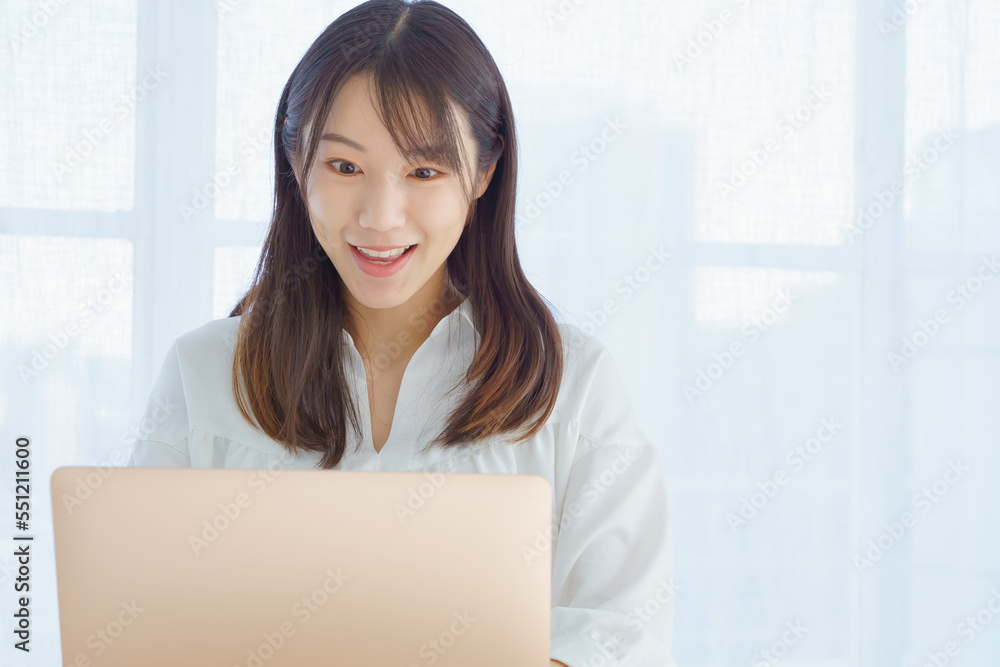 パソコンをみて驚く表情をする女性 パソコンをみて驚く表情をする女性