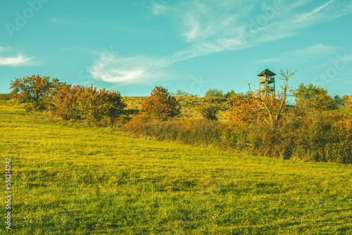 Watchtower on the green meadow on a sunny day.Autumn landscape.