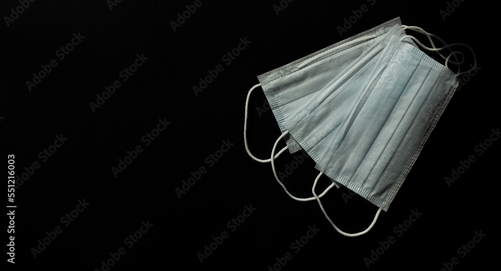 Medical masks on a black background on the right. Space for text. View from above.