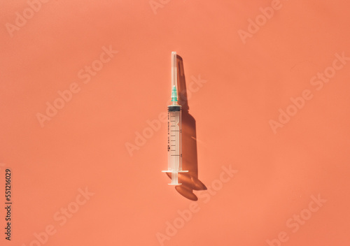 Syringe on a red background. Space for text. View from above. Flatlay.