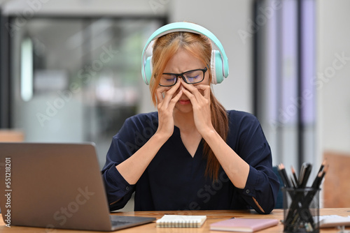 Young tired overworked woman freelance or student feeling eye strain and fatigue during computer work or learning online.