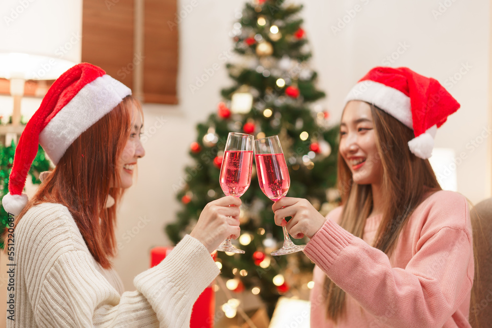 Christmas concept, Two women in santa hat holds champagne glasses to celebrate in christmas festive Christmas concept, Two women in santa hat holds champagne glasses to celebrate in christmas festive