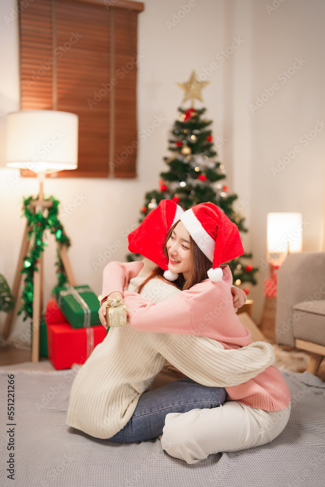 Christmas celebration concept, Two beautiful women exchanging christmas gift and hugging together Christmas celebration concept, Two beautiful women exchanging christmas gift and hugging together