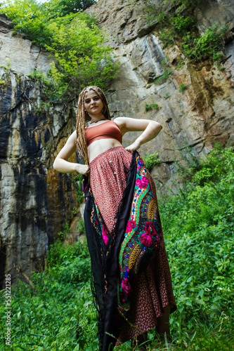 Beautiful girl with dreadlocks  dressed hippie style poses outdoors.