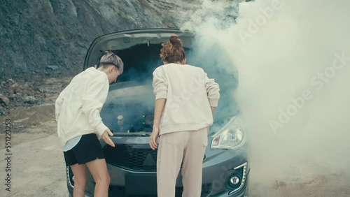 The car broke down on a country road, white smoke under the hood