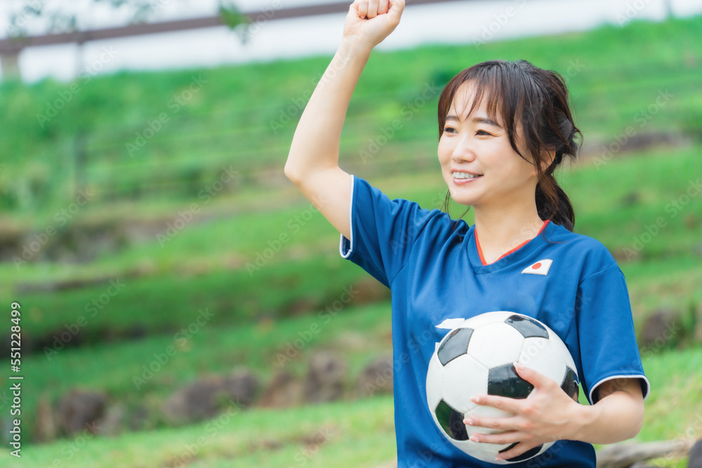 Obraz premium サッカーボールを持ちながらサッカーで勝利してガッツポーズするサッカーファン・サポーター 