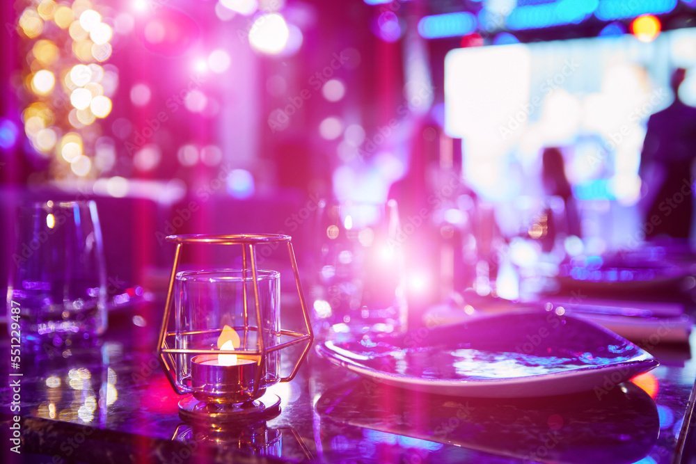 Served table of a night club against the background of multi-colored lights Served table of a night club against the background of multi-colored lights