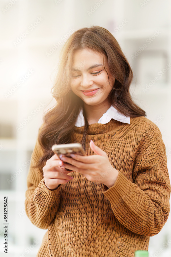 Young Asian Woman using smart phone at home. Female holding cellphone checking email or social media on internet Young Asian Woman using smart phone at home. Female holding cellphone checking email or social media on internet