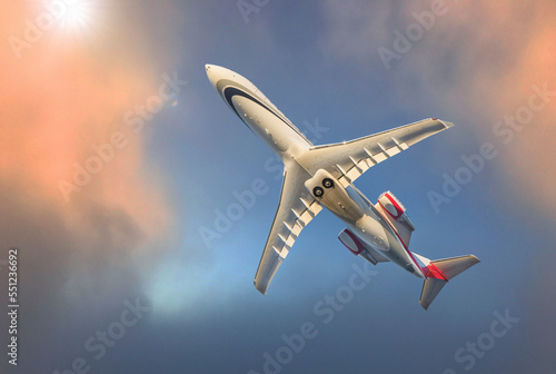 Commercial airliner against a blue sky with clouds at sunset