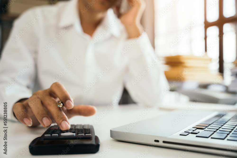 Fototapeta premium Businessman working on desk office with using a calculator to calculate tax.