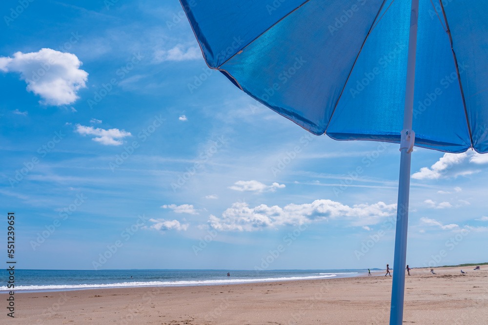 Part of a blue umbrella against a blue sky on the beach