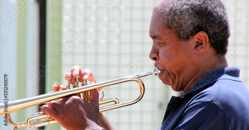 African american jazz reumpet player blowing his horn outside.