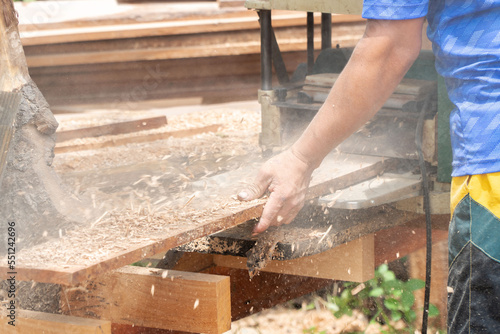 Joiner, Man's hand scouring a wooden board on a thickness machine in garden. Carpenter working with electric planer on wooden beam, plank.DIY concept