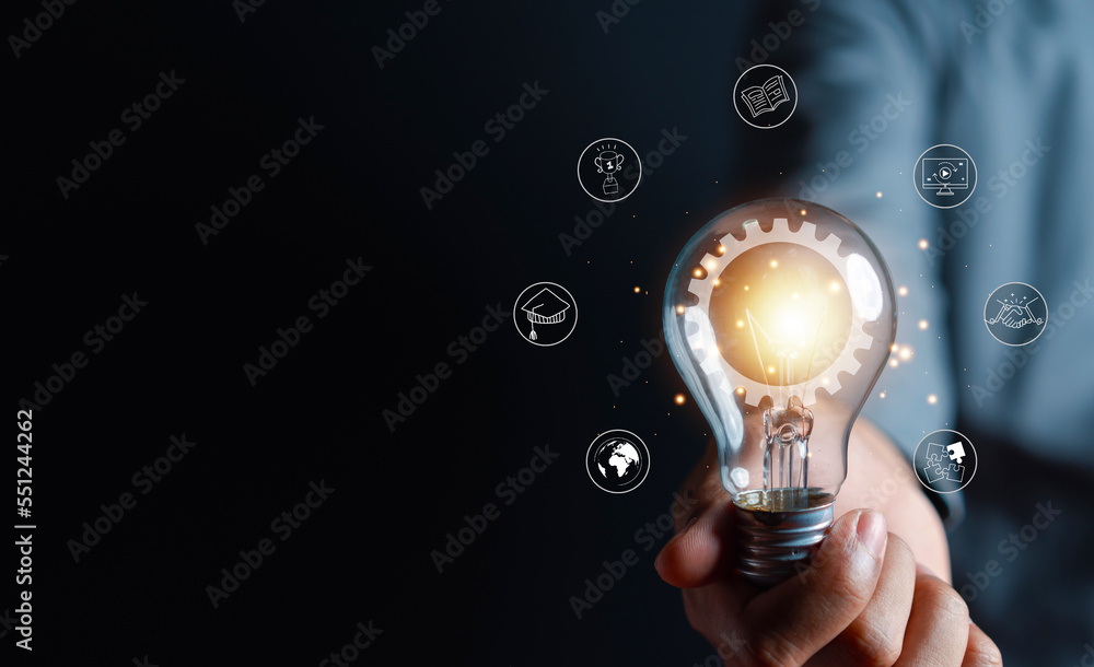 Man hand holding lightbulb with learning educate and graduation concept ...