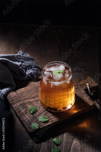 Cup of ice tea with fresh mint leaves on dark background