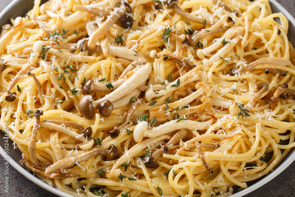 Creamy spaghetti with beech mushrooms with parmesan and thyme close-up in a plate on the table. horizontal Creamy spaghetti with beech mushrooms with parmesan and thyme close-up in a plate on the table. horizontal