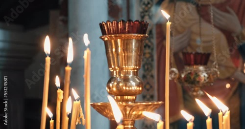 Burning candles with a golden candlestick in an Orthodox church. Concept of Orthodox, Christianity, worship, beliefs, funeral services and religion