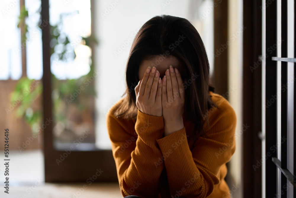 両手で顔を覆う女性