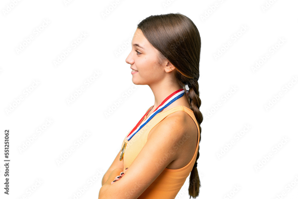 Teenager caucasian girl with medals over isolated background in lateral position Teenager caucasian girl with medals over isolated background in lateral position