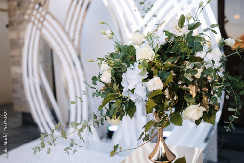 Elements of decor on wedding. Luxyry restaurant. White decor with green photo