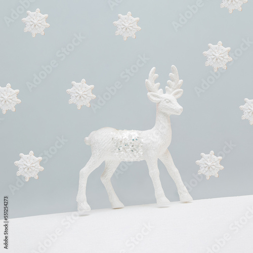 Minimal abstract aesthetic Xmas greeting card with white reindeer and cookies in the shape of snowflakes on isolated gray background. New Year holiday decoration concept. Christmas symbol. © jbuinac