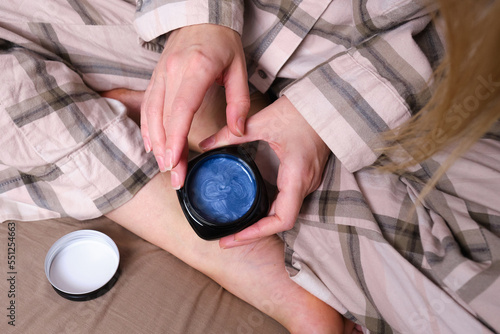 Woman's hands and a jar of body cream close-up on a natural background. Spa body care. Copy space