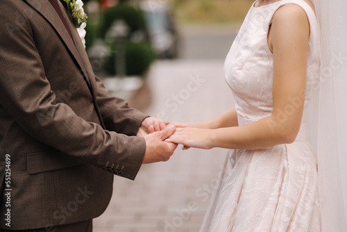 Middle celection of groom and bride take each other's hands outdoors. Wedding concept