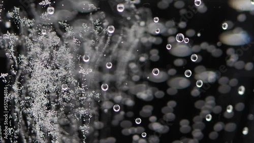 A glass of sparkling water on a black background. Bubbles come out of the glass. Pure mineralized water with gas.