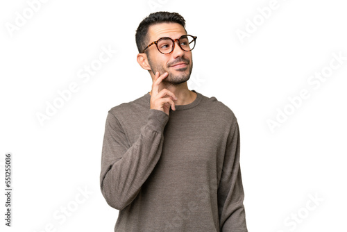 Young handsome caucasian man over isolated background thinking an idea while looking up