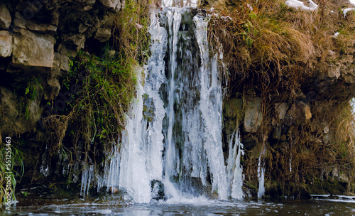 small beautiful waterfall in the winter time. waterfall with ice © Gints 