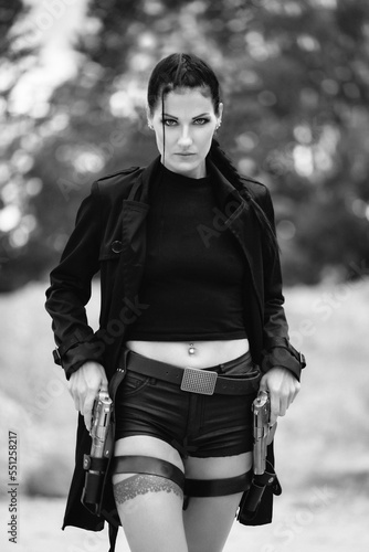 Lara Croft Tomb Raider action movie cosplay costume photoshoot with guns and weapons brunette female model Black and white version 