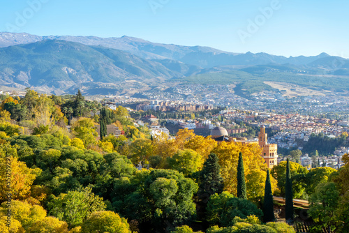Green gardens of Alhambra on mountains peak covered by snow in Granada, Spain on November 26, 2022