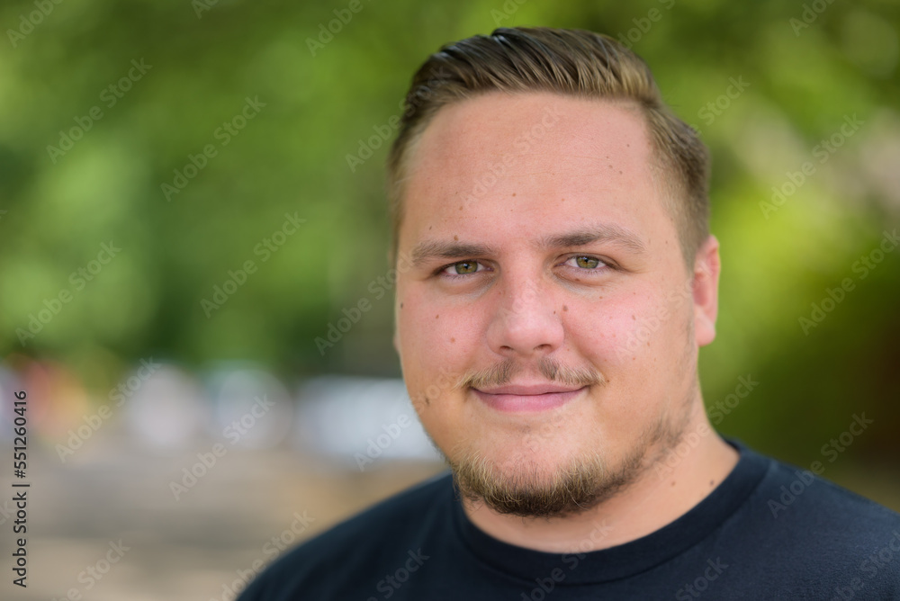Young man smiling at the camera in amusement Young man smiling at the camera in amusement