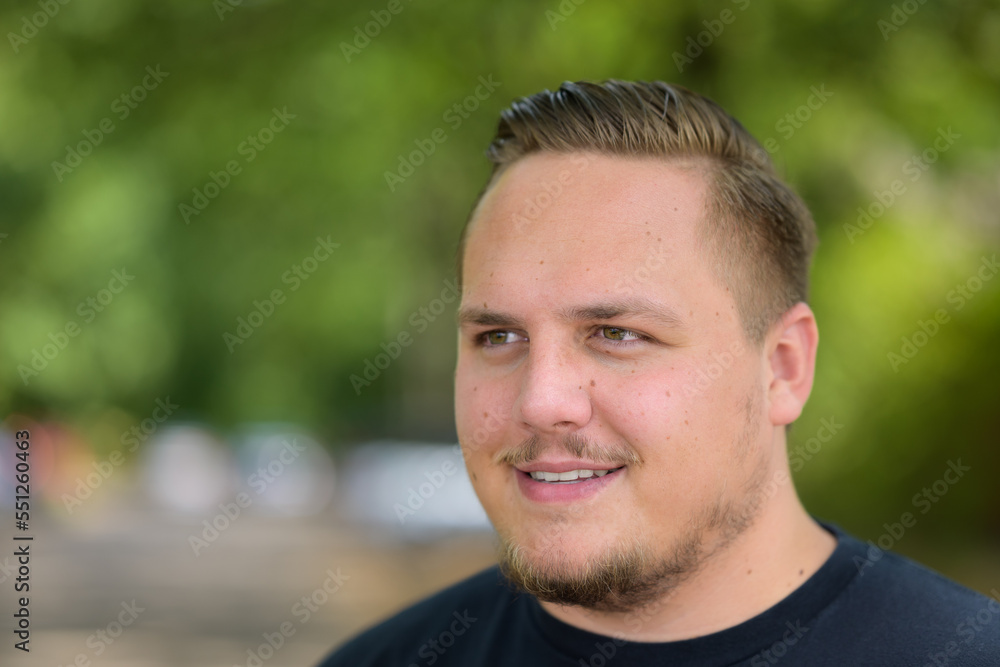 Young man looking aside with a quiet smile Young man looking aside with a quiet smile
