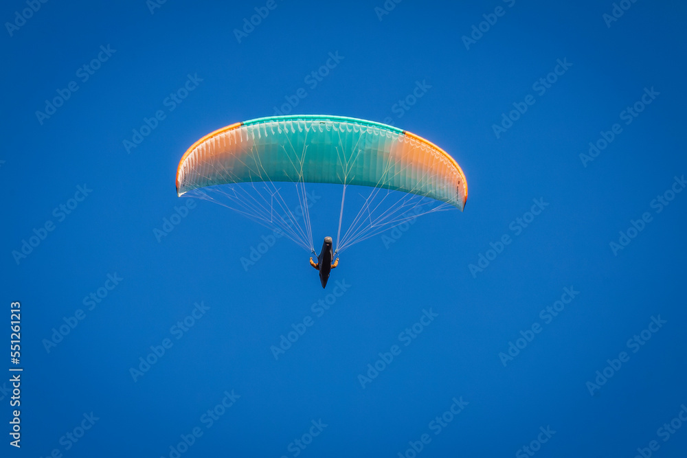 Vizille, Isere, Rhone-Alpes, France, 20 11 2022 green and orange paraglider flying in the sky Vizille, Isere, Rhone-Alpes, France, 20 11 2022 green and orange paraglider flying in the sky