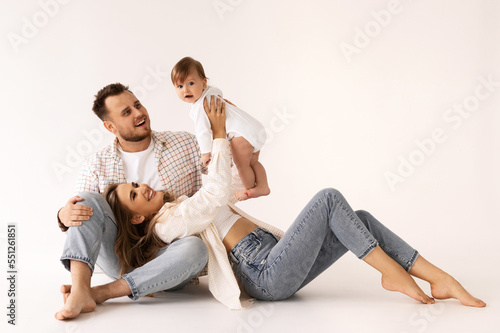 family portrait on a white background, happy family concept portrait. the parents play with the child.