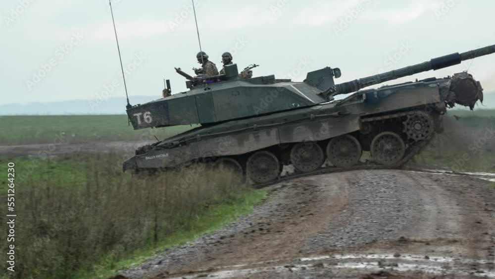 British army Challenger 2 II FV4034 tank with commander and gunner on turret station traversing a high mud track on a military battle exercise, Wiltshire UK British army Challenger 2 II FV4034 tank with commander and gunner on turret station traversing a high mud track on a military battle exercise, Wiltshire UK