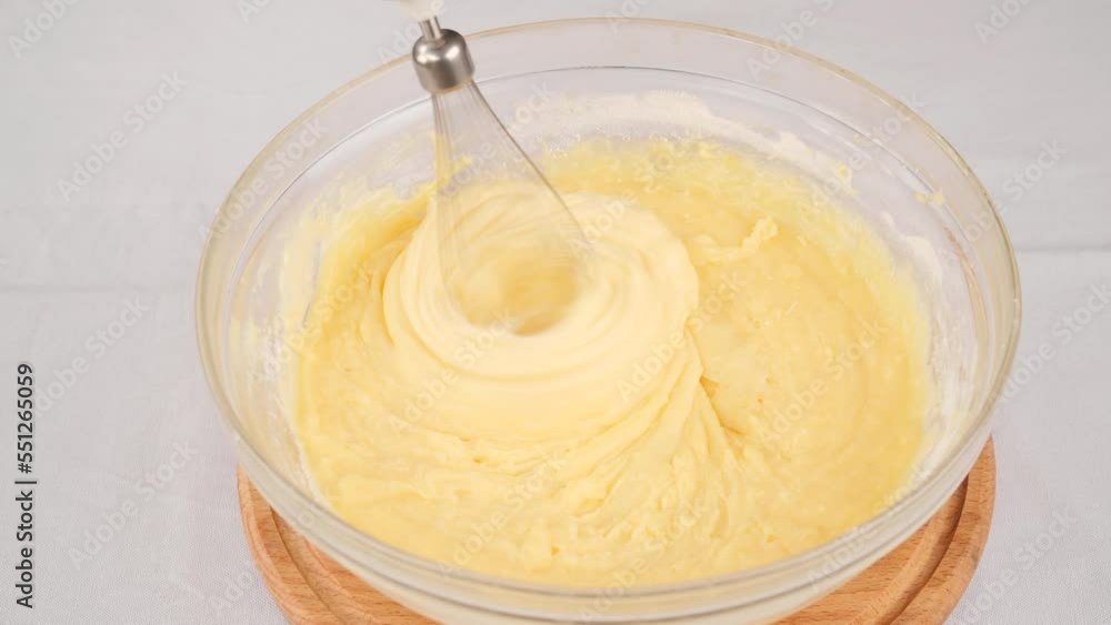 Kneading the dough with a whisk of a blender in bowl Kneading the dough with a whisk of a blender in bowl