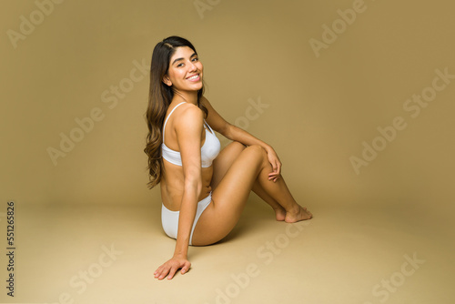 Excited woman laughing and relaxing in underwear for a beauty concept