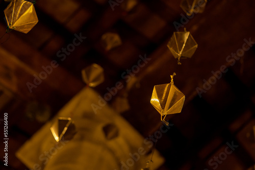 Low angle detail of a golden diamond hanging from the wooden ceiling of the granollers porch followed by two o more above it photo