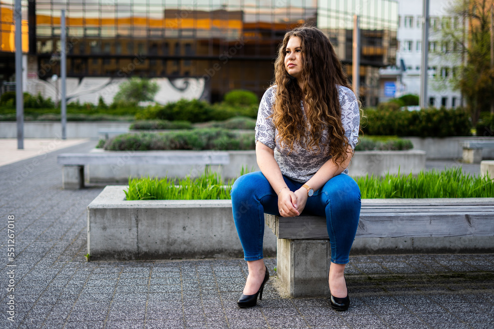 Young brunette woman sitting on a bench Young brunette woman sitting on a bench