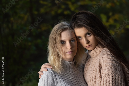 Portrait of beautiful two girls posing for the camera outdoors. Horizontally.