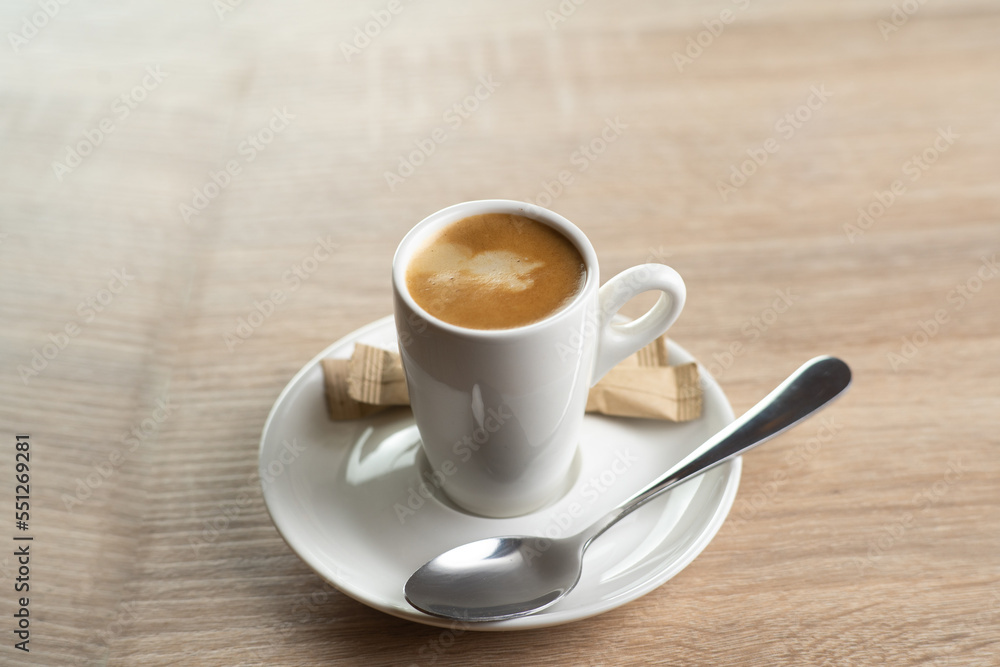 A white cup of coffee, top view on wooden background