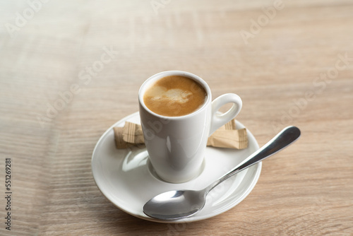 A white cup of coffee, top view on wooden background