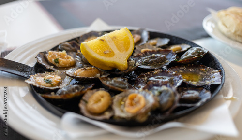 limpets sea fruits grilled on rustic frying pan