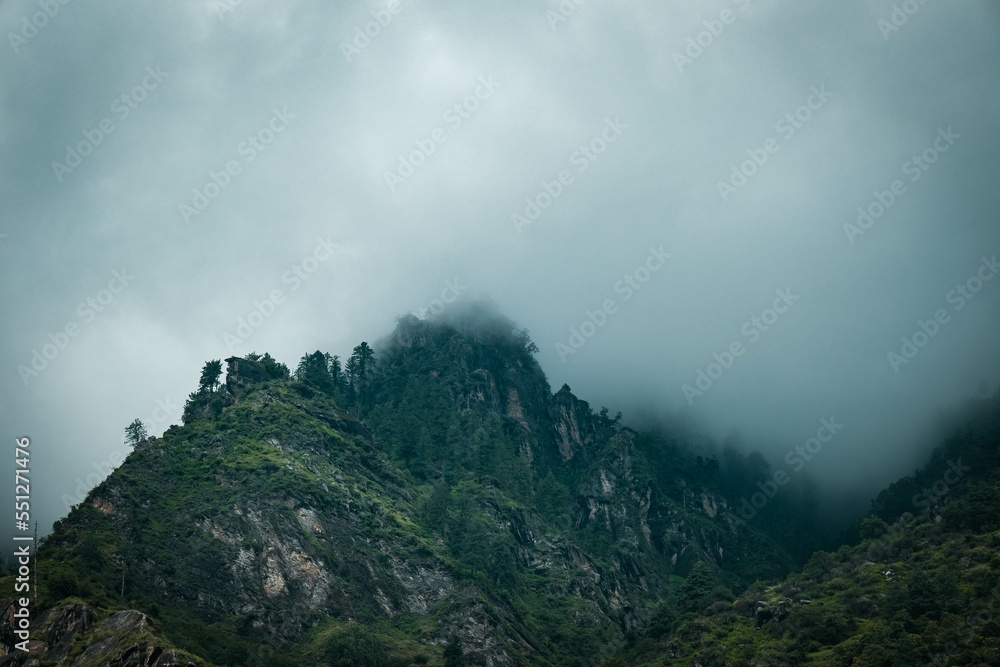 View of green mountains covered in clouds 