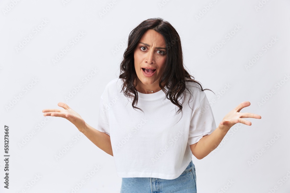 Woman in white t-shirt on white background brunette hands up gestures and signals poses in jeans emotion, lifestyle smiles, copy space Woman in white t-shirt on white background brunette hands up gestures and signals poses in jeans emotion, lifestyle smiles, copy space