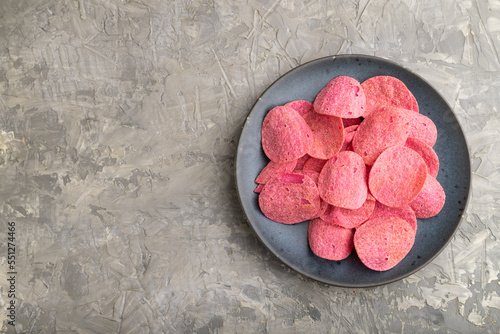 red potato chips on gray concrete background. Top view, copy space.