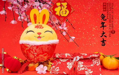 Tradition Chinese cloth doll rabbit,2023 is year of the rabbit,Chinese golden characters Translation:good bless for year of the rabbit,rightside word and seal mean:Chinese calendar for the year photo